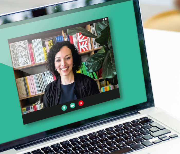 Blick auf einen Laptop mit lächelnder Frau.