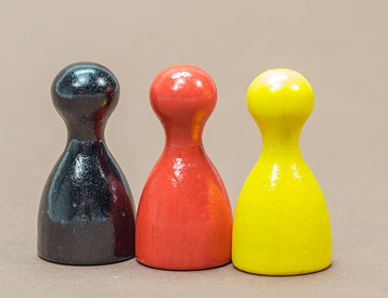 Drei Spielfiguren aufgereiht in Deutschland Farben.